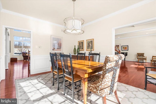 dining room featuring wood-type flooring, a chandelier, and crown molding