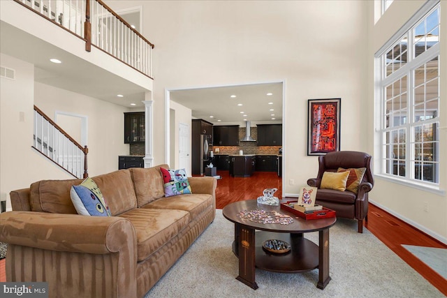 living room with wood-type flooring and a towering ceiling