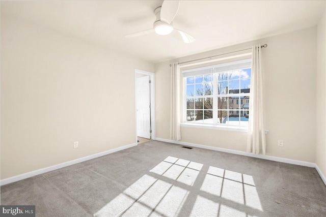 carpeted spare room with ceiling fan