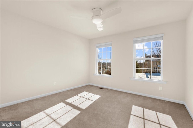 empty room with ceiling fan and light carpet