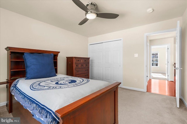 carpeted bedroom with ceiling fan and a closet