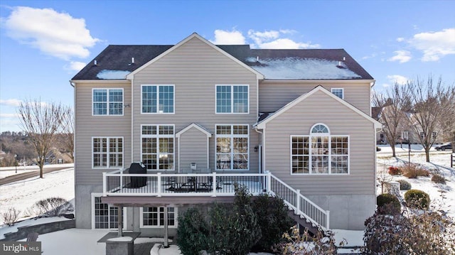 snow covered rear of property featuring a wooden deck