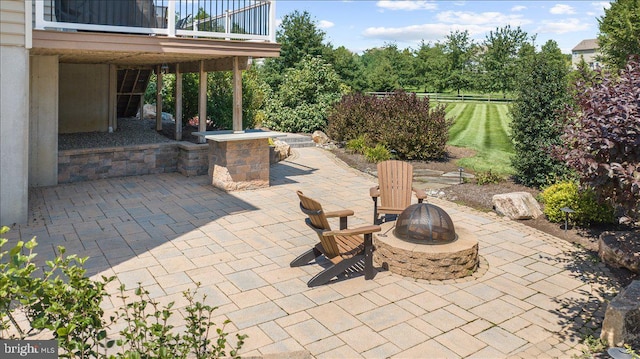 view of patio with a balcony and an outdoor fire pit