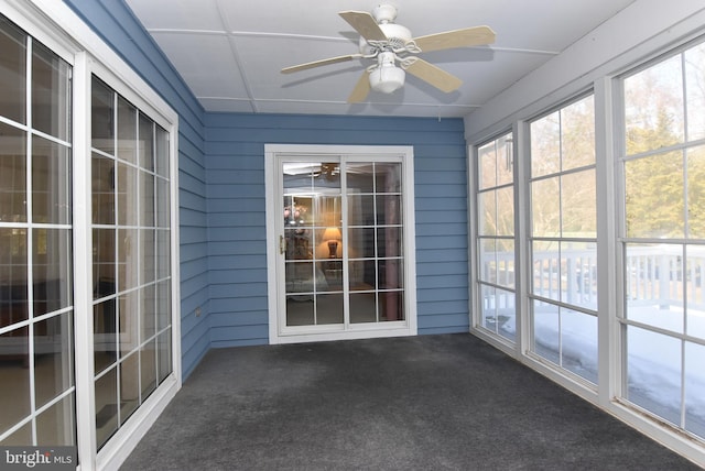 unfurnished sunroom featuring ceiling fan