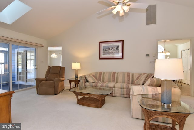 living room featuring light carpet, a skylight, high vaulted ceiling, and ceiling fan