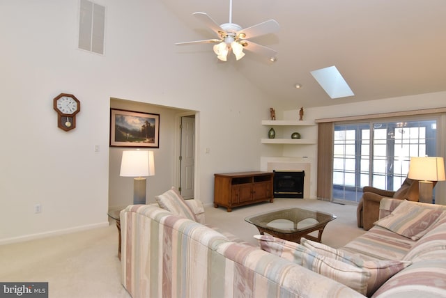 living room featuring light carpet, a skylight, high vaulted ceiling, and ceiling fan