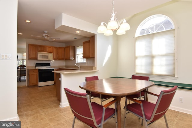 dining room with ceiling fan with notable chandelier