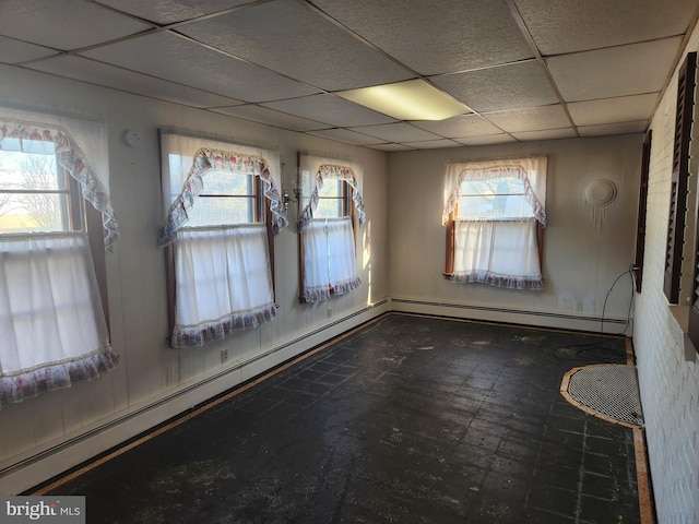 spare room with baseboard heating and a paneled ceiling