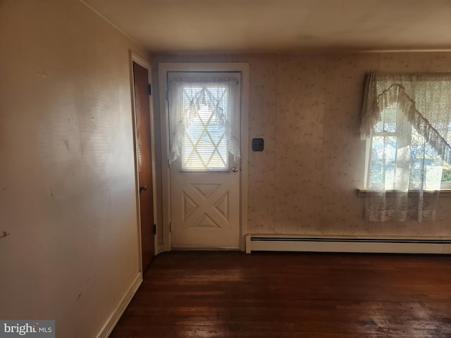 doorway featuring baseboard heating and dark hardwood / wood-style floors