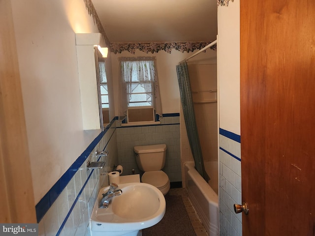 full bathroom with toilet, tile walls, sink, shower / bath combination with curtain, and tile patterned floors