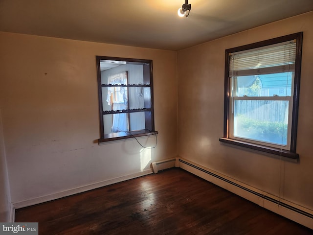 spare room featuring a baseboard radiator and dark wood-type flooring