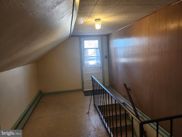 bonus room with a baseboard radiator, wooden walls, and vaulted ceiling