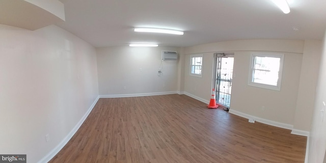 empty room with dark hardwood / wood-style floors and an AC wall unit