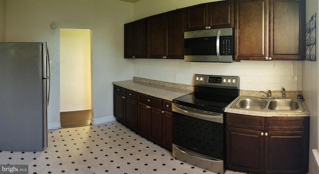 kitchen with sink, dark brown cabinets, decorative backsplash, and appliances with stainless steel finishes