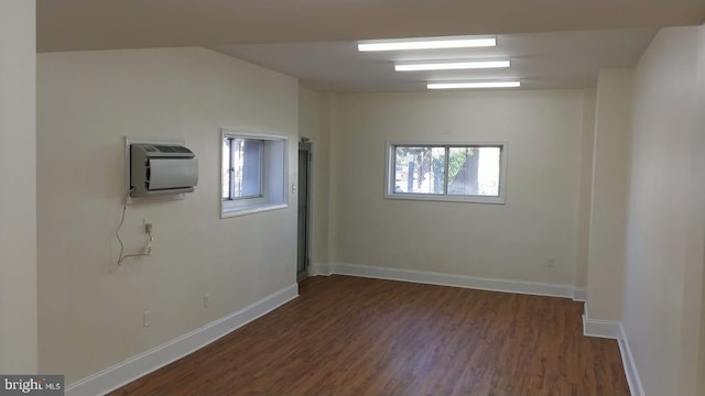 unfurnished room featuring dark hardwood / wood-style flooring and a wall mounted AC