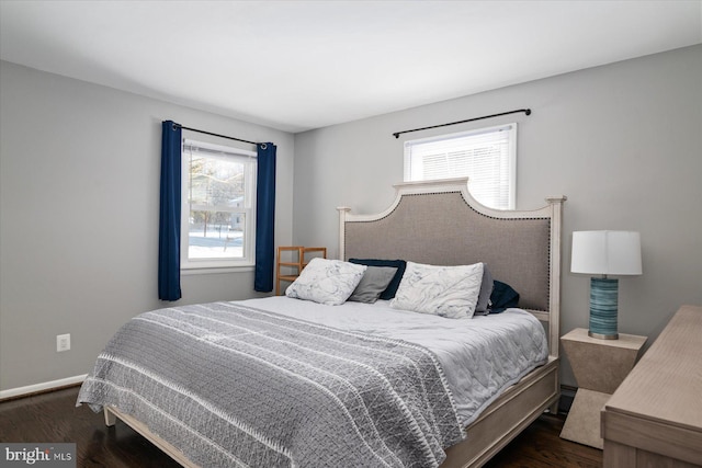 bedroom featuring dark hardwood / wood-style flooring and multiple windows