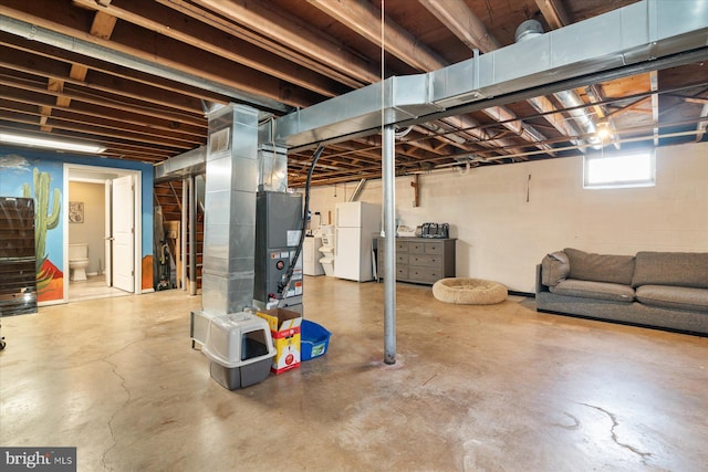 basement with heating unit and white fridge