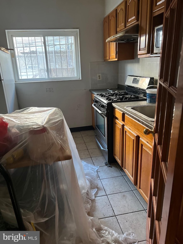 kitchen featuring sink, gas stove, and light tile patterned floors