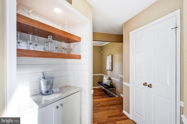 bar featuring wood finished floors and baseboards