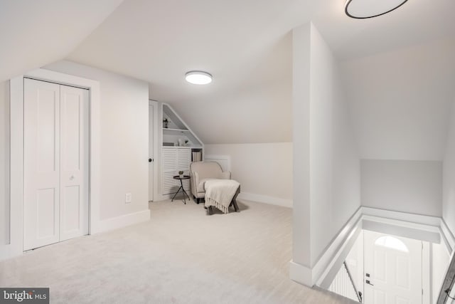 bedroom with carpet, a closet, vaulted ceiling, and baseboards