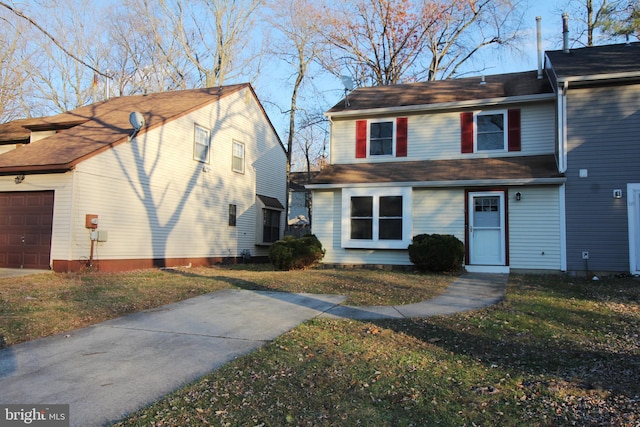 view of property featuring a garage and a front lawn