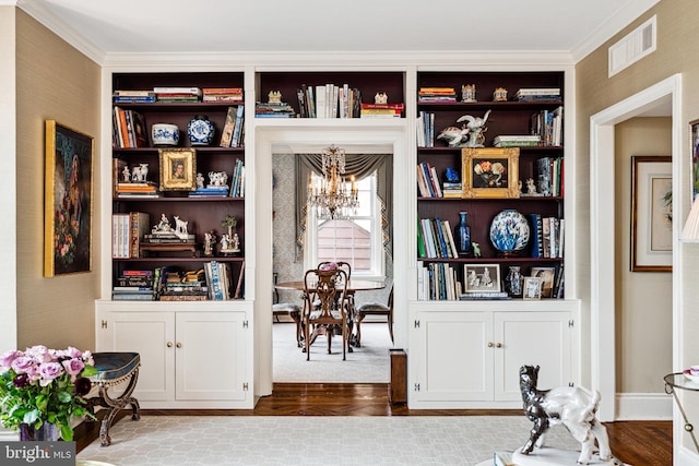 sitting room with wood-type flooring, an inviting chandelier, and ornamental molding