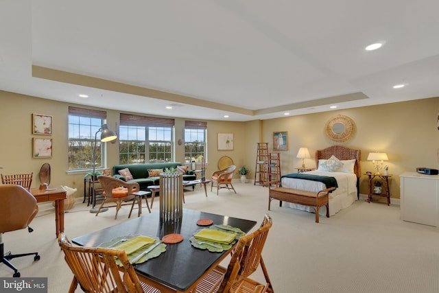 carpeted bedroom with a raised ceiling