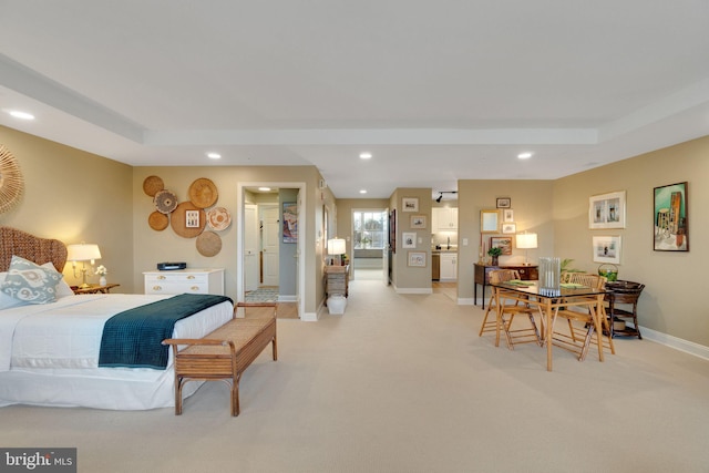 bedroom featuring light carpet and a raised ceiling