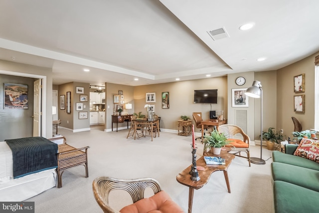 carpeted living room with a tray ceiling