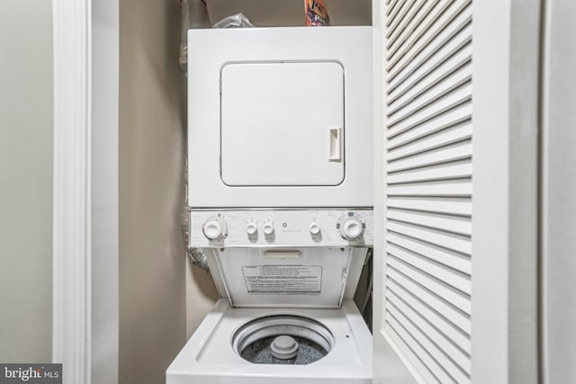 clothes washing area featuring stacked washing maching and dryer