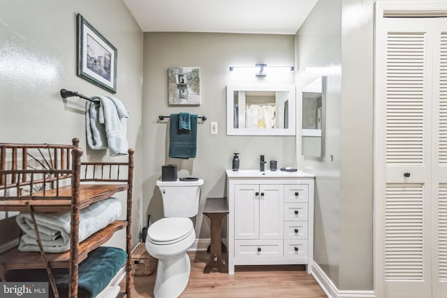 bathroom with vanity, toilet, and hardwood / wood-style floors