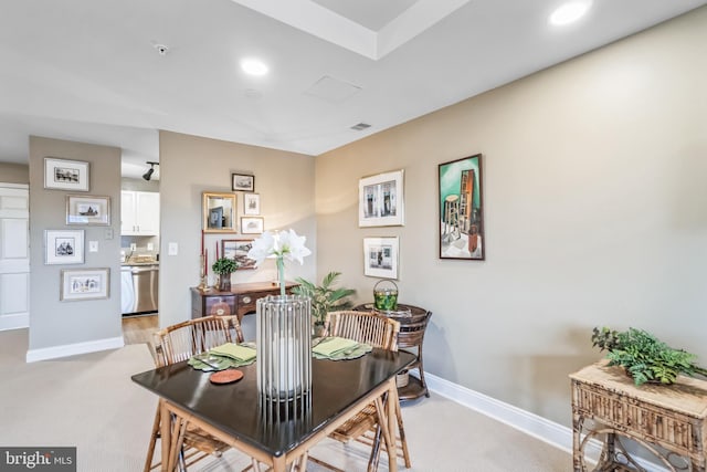 dining space featuring light carpet