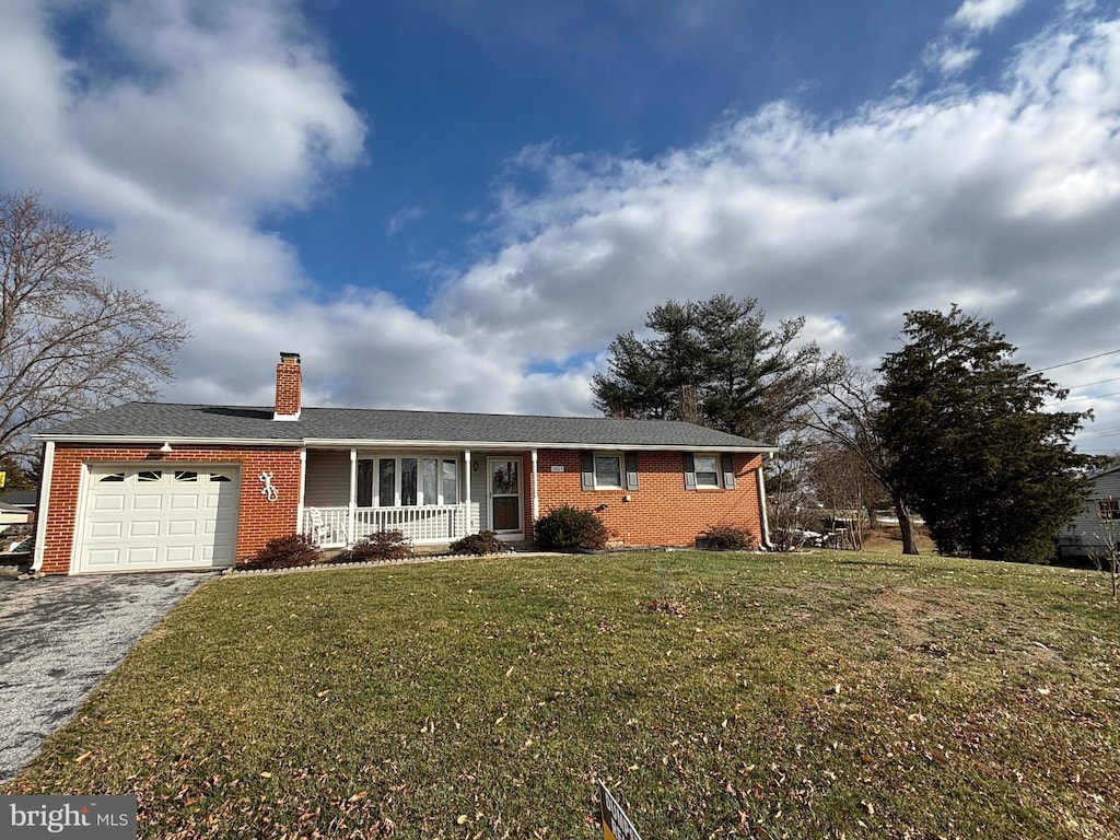 single story home with a front yard, a porch, and a garage