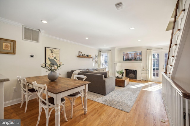 dining room featuring ornamental molding and light wood-type flooring