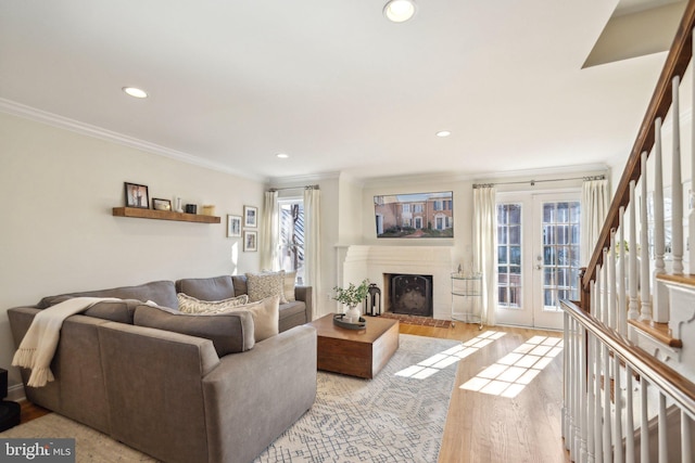 living room featuring crown molding, light hardwood / wood-style floors, and french doors