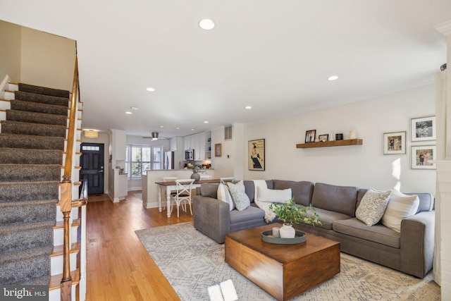 living room featuring wood-type flooring and ornamental molding