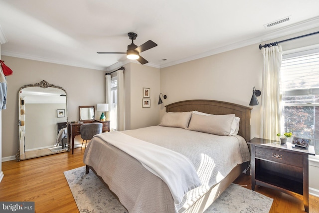 bedroom featuring ornamental molding, ceiling fan, and light wood-type flooring