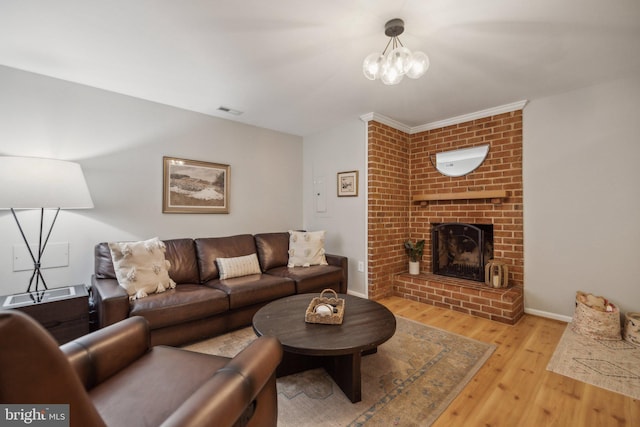 living room featuring a brick fireplace and light wood-type flooring