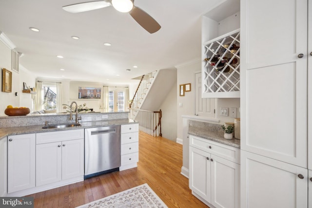 kitchen with white cabinetry, dishwasher, sink, light hardwood / wood-style floors, and light stone countertops