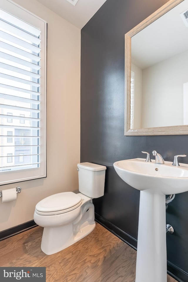 bathroom featuring a sink, wood finished floors, toilet, and baseboards