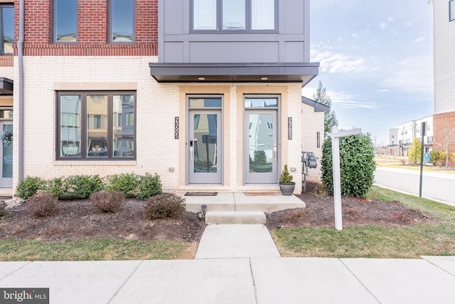 entrance to property featuring brick siding