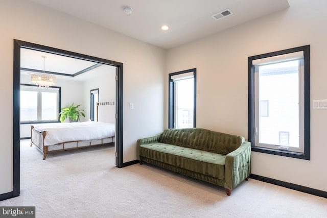 living area featuring visible vents, light carpet, and baseboards