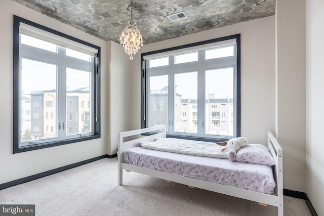 bedroom featuring an inviting chandelier, light colored carpet, visible vents, and baseboards