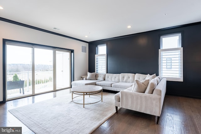 living room with recessed lighting, visible vents, dark wood-type flooring, and ornamental molding