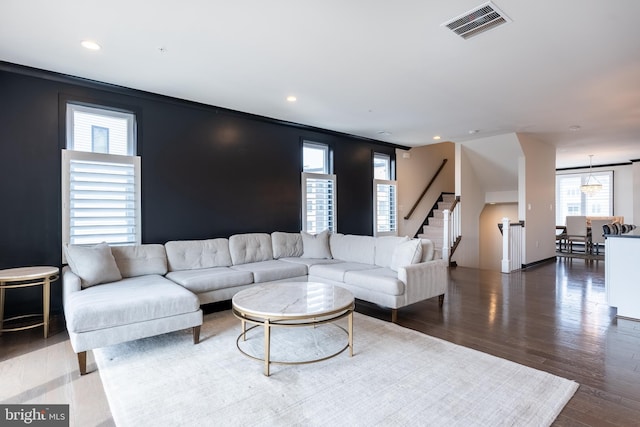 living area with recessed lighting, wood finished floors, visible vents, and stairs