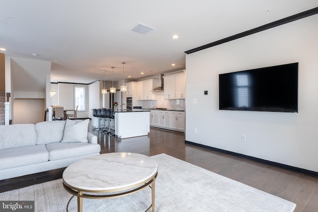 living room with dark wood-type flooring, recessed lighting, visible vents, and baseboards