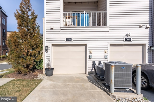 garage featuring concrete driveway and cooling unit