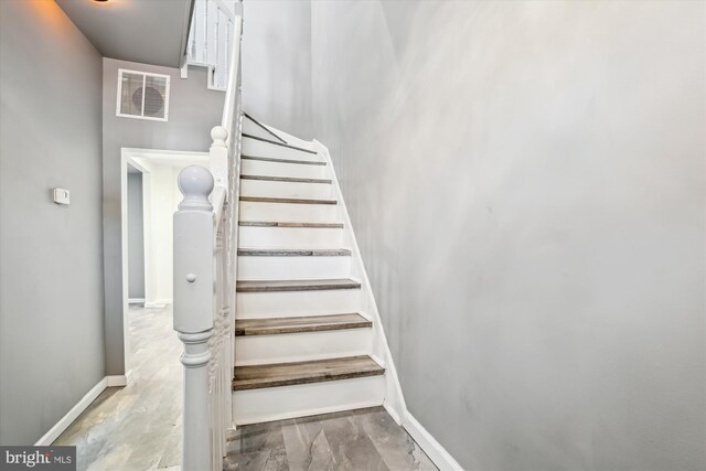 stairs featuring hardwood / wood-style flooring