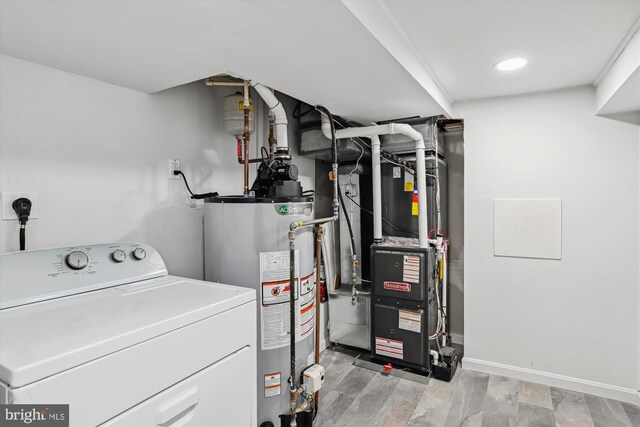 clothes washing area with gas water heater, heating unit, and washer / dryer