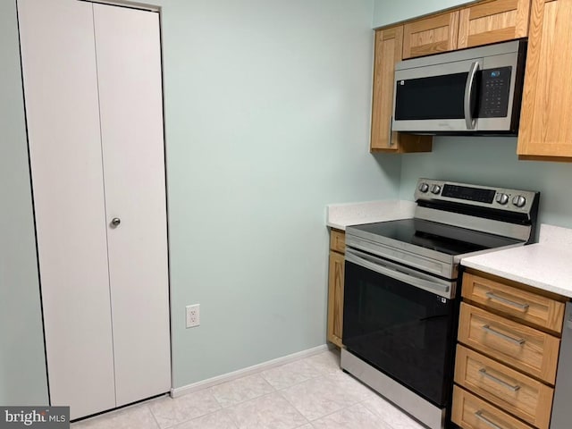 kitchen with light tile patterned floors and appliances with stainless steel finishes